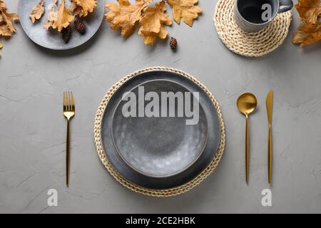 Autumn table setting with seasonal harvest and gold decor on grey table. Flat lay, top view. Space for text. Stock Photo