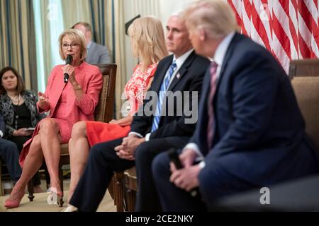 U.S. President Donald Trump, right, listens as Secretary of Education Secretary Betsy DeVos remarks during a roundtable on Kids First: Getting American Children Safely Back to School in the State Dining Room of the White House August 12, 2020 in Washington, DC. Stock Photo