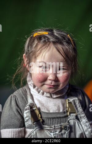 Portrait of a 7 years old young Nenet girl inside a chum (traditional tent), Yamalo-Nenets Autonomous Okrug, Russia Stock Photo