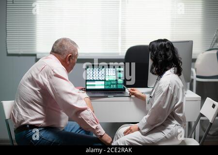 A man and a woman are looking at the x-ray on the monitor of the lap top. Stock Photo
