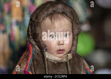 Portrait of a 2 years old Nenet child with traditional wear inside a chum (traditional tent), Yamalo-Nenets Autonomous Okrug, Russia Stock Photo
