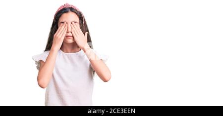 Cute hispanic child girl wearing casual white tshirt rubbing eyes for fatigue and headache, sleepy and tired expression. vision problem Stock Photo