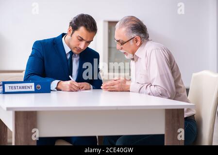 Young lawyer visiting old man in testament concept Stock Photo