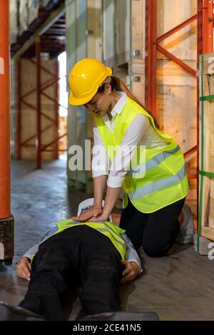 Warehouse worker do CPR after accident Stock Photo