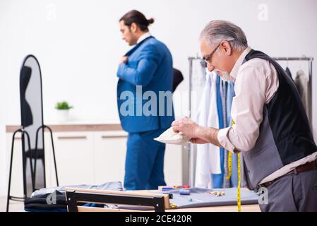 Young businessman visiting old tailor Stock Photo