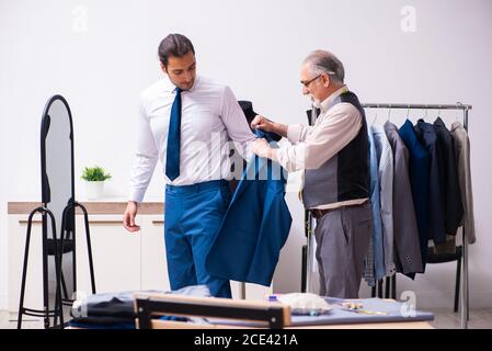Young businessman visiting old tailor Stock Photo