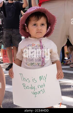 August 30, 2020, Boston, Massachusetts, USA: A young child holds a 'This is my body, not yours!' sign during anti flu shot mandate rally in Boston. Hundreds of the anti flu shot protesters rally against Massachusetts flu vaccine mandate outside of the Statehouse on August 30, 2020. Massachusetts public health officials announced on August 19 that influenza immunization were now required for all students over 6 months old at pre-school, K-12, and colleges unless either a medical or religious exemption is provided. Students will be expected to have received a flu vaccine by December 31, 2020, Stock Photo