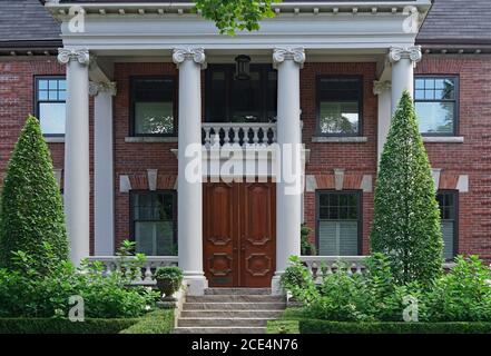 Elegant double wooden front door and entrance with columns, mansion or college building Stock Photo