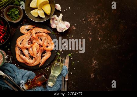 Seafood composition with shrimps or prawns. Seved on dark background with many ingredients. Flat lay Stock Photo