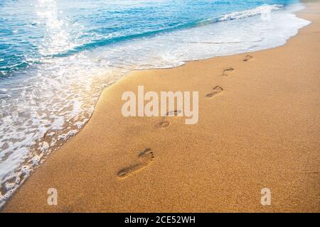 footprints on  tropical beach and beautiful  wave Stock Photo
