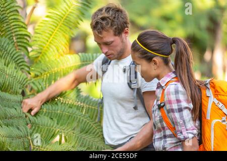 Nature guide biologist naturalist botanist teacher teaching to student about plants and biology. Interpretive walk in rain forest, hiking people Stock Photo