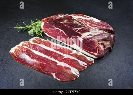 Traditional dry cured and smoked ham offered on a black board Stock Photo