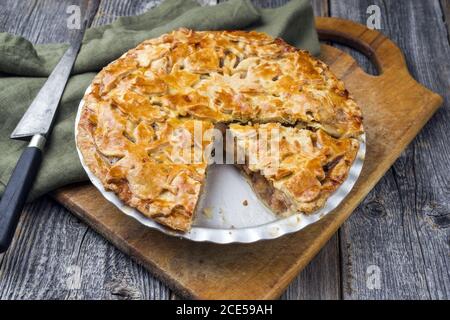 Traditional apple jalousie cake offered as closeup in a backing form on an old rustic wooden board Stock Photo