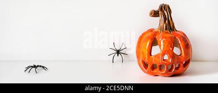 Ceramic pumpkin jack lantern and autumn leaves garland on table wall banner Stock Photo