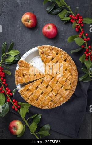 Traditional apple jalousie cake offered as top view in a backing form with decoration on a black board Stock Photo