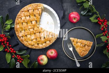 Traditional apple jalousie cake offered as top view on a modern design plate and backing form with decoration on a black board Stock Photo