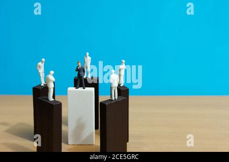 Business conceptual photo – group miniature of businessman have group discussion above wooden puzzle block Stock Photo