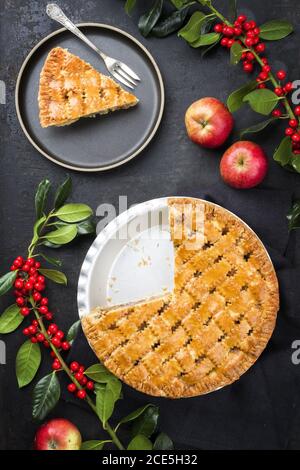 Traditional apple jalousie cake offered as top viewon modern design plate and backing form with decoration on a black board Stock Photo