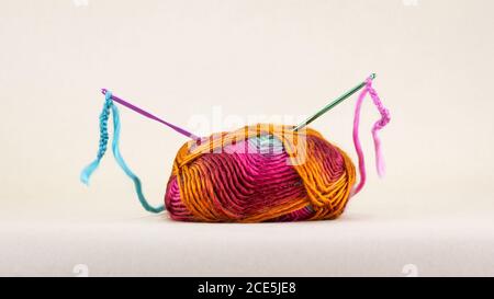 Colourful single ball of wool with crochet hooks and thread, Stock Photo