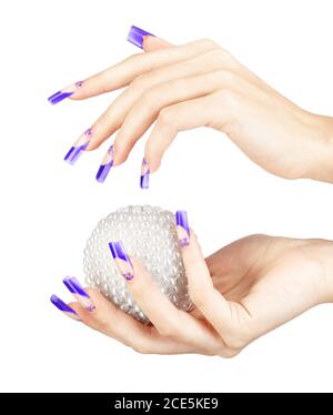 Hands with blue french false acrylic nails manicure holding perl christmas ball Stock Photo