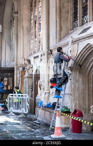 Worker Work By Racking Workers in orange and red protective gloves handle blackened fragments ...