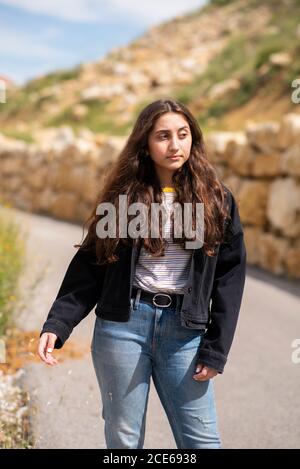 Serious teenage girl looking away outdoors Stock Photo