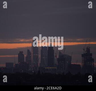 London, UK. 31 August 2020. Skyscrapers on the London skyline on Bank Holiday Monday seen from Wimbledon as a cloudy dawn breaks. City office buildings remain quiet as financial workers continue to work from home during the Covid-19 pandemic. Credit: Malcolm Park/Alamy Live News. Stock Photo