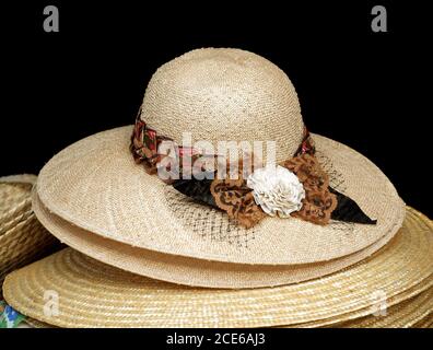 Handmade straw hats with colorful ribbons are on display Stock Photo