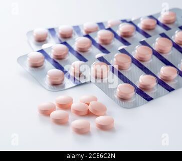Pink pills placed on a white background Stock Photo