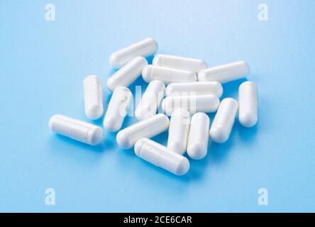 White capsules placed on blue background Stock Photo