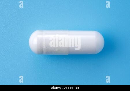 White capsules placed on blue background.Medical, health image Stock Photo