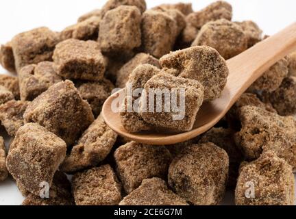 Close-up shot of a lump of brown sugar in a wooden spoon Stock Photo