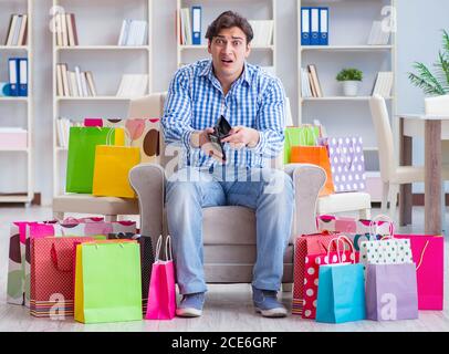 The young man after excessive shopping at home Stock Photo