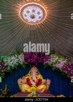 Lord Ganesha decorated with orchid flowers Stock Photo