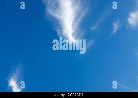 White cirrus clouds on a background of dark blue sky. Copy space for text. Stock Photo