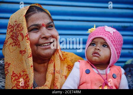 India - March 9, 2020: Indian mother sitting on bench with little daughter Stock Photo