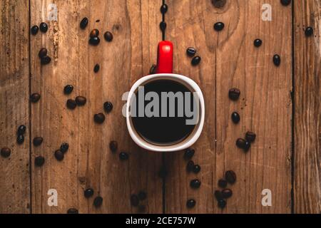 Top view of delicious beverage in mug placed on table with coffee beans Stock Photo