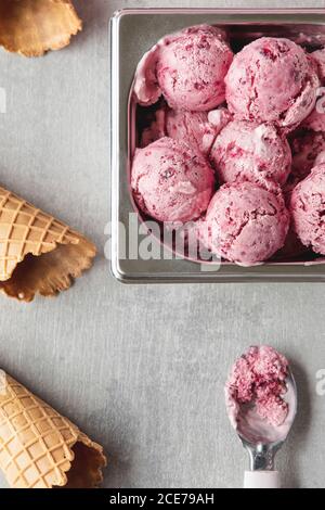 From above of delicious homemade cherry ice cream scoops arranged on table with waffle cones Stock Photo