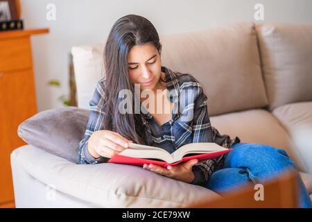 Young Woman reading book at home Stock Photo
