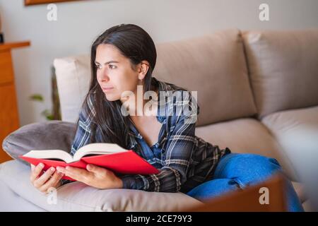 Young Woman reading book at home Stock Photo