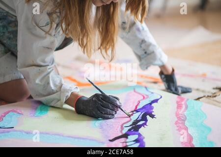 Girl painting with bright gouache paper floor Stock Photo - Alamy