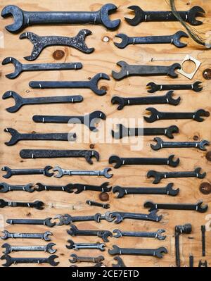 Set of different nut wrenches on brown board in studio Stock Photo