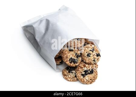 Healthy  protein granola crackers with raisins and nuts in paper bag isolated on white Stock Photo