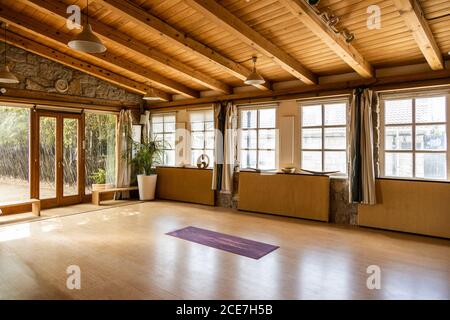 Yoga mat placed on wooden floor inside spacious pavilion decorated in oriental style located in tropical country Stock Photo