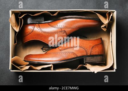 Brown shoes in a box on a black background. New shoes made of