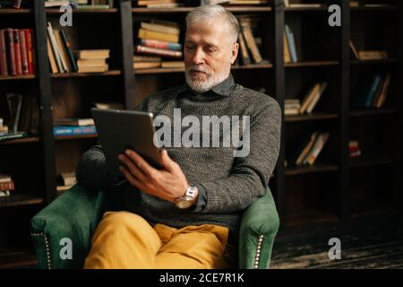 Gray-haired mature adult male is speaking on video call with friend client colleague family Stock Photo