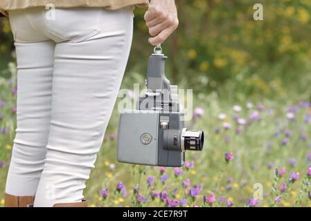 Crop photographer walking in park with vintage video camera Stock Photo