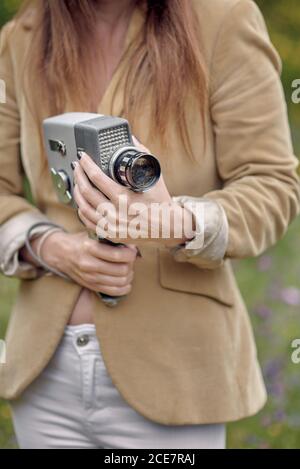 Crop photographer walking in park with vintage video camera Stock Photo
