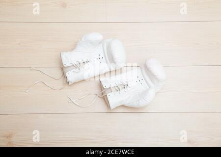 White boxing gloves on wooden floor Stock Photo