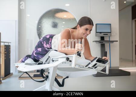 Woman doing exercises using a gravity trainer Stock Photo